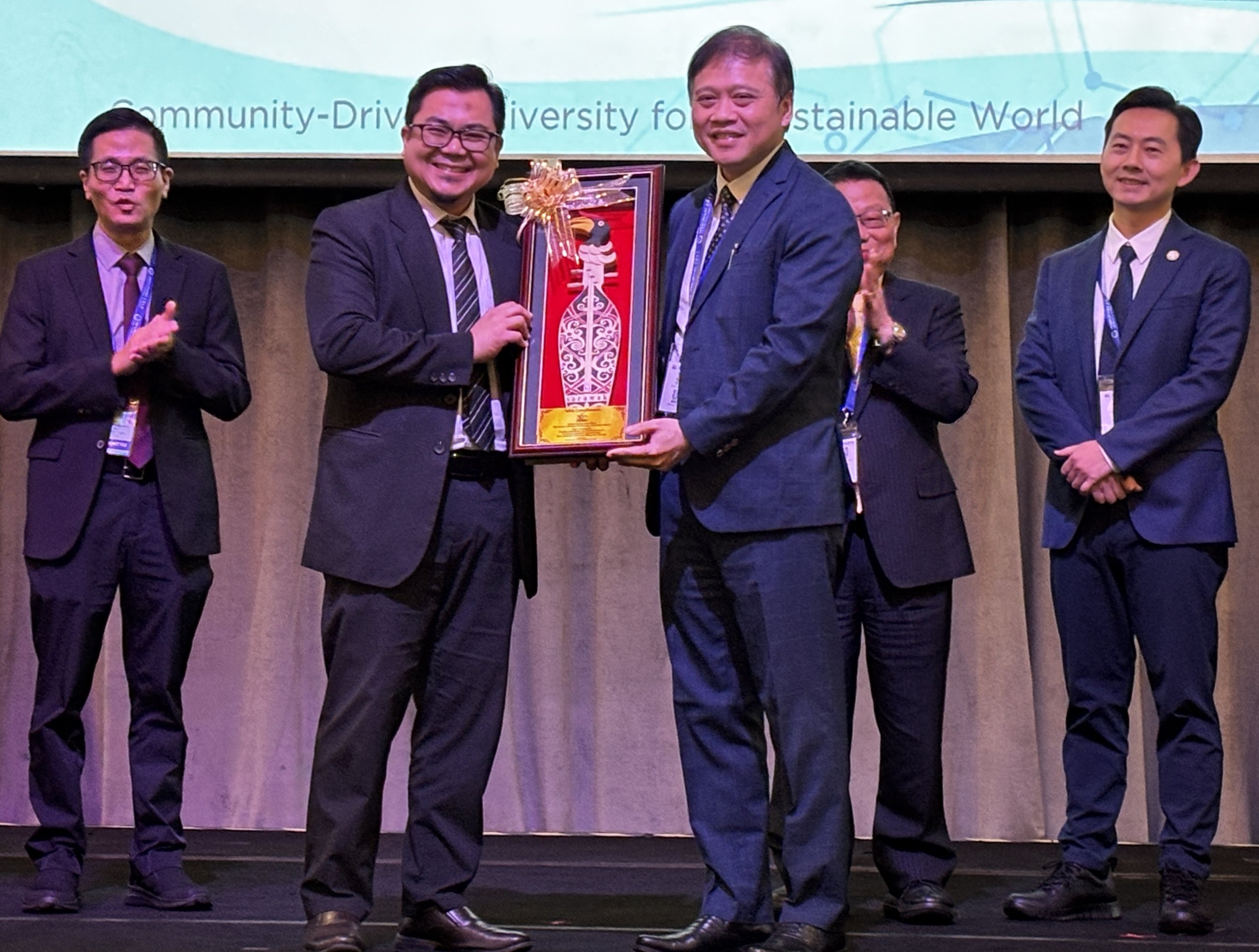 Asri presents a memento to Huang during the opening of the symposium in Kuching.